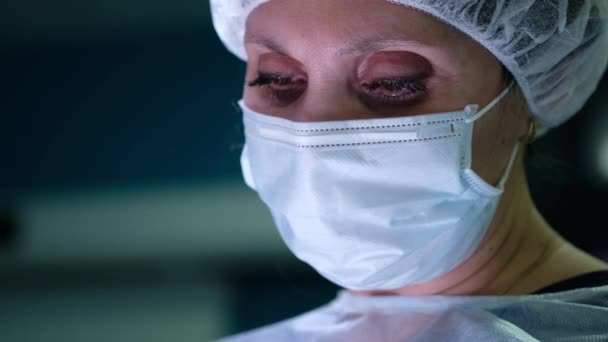 Primo piano di un occhio femminile chirurghi. Ritratto di chirurgo donna durante l'intervento . — Video Stock
