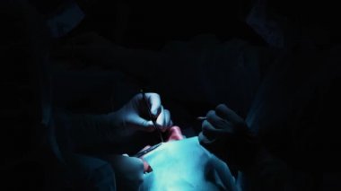 Cerrah bir operasyonu göze, yakın çekim. Gözleri ve göz düzeltme. Doktor Blefaroplasti yapar. Ameliyathane işlem. Neşter ve kelepçe yakın öğrenci çok.
