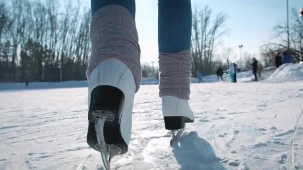 Mujer joven patinando sobre hielo con patines de figuras al aire libre en la nieve — Vídeos de Stock