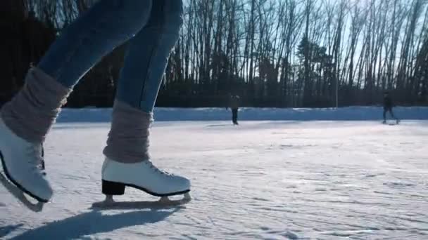 Mujer joven patinando sobre hielo con patines de figuras al aire libre en la nieve — Vídeos de Stock