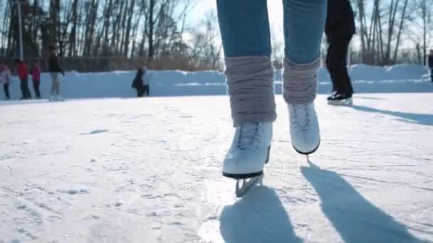 Mujer joven patinando sobre hielo con patines de figuras al aire libre en la nieve — Vídeo de stock
