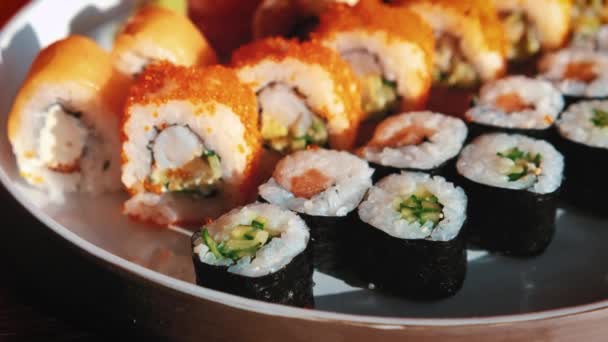 Junge Frau im Café isst Sushi mit Stäbchen — Stockvideo
