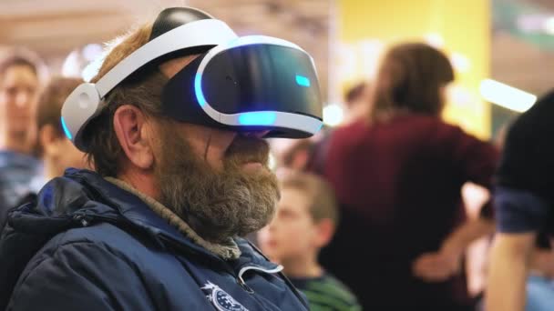 Ιανουαρίου 2018 - εικονική πραγματικότητα ακουστικό - πατέρας δοκιμάζοντας τη νέα τεχνολογία. Ο ηλικιωμένος άνδρας προσπαθεί νέες τεχνολογίες. Προσπαθώντας γυαλιά εικονικής πραγματικότητας — Αρχείο Βίντεο