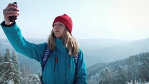 Fiatal lány turisztikai csinálás fotó selfie álló okostelefon, télen. Boldog turista lány utazás-szúró telefon használ a gyönyörű természeti táj. — Stock videók