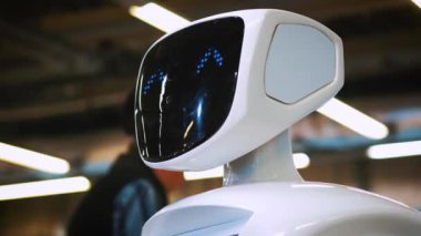 Yeni modern beyaz robot portresi. Robot onun kafa döner, kameraya doğru görünüyor. Robotlar ve yüksek robot Teknolojileri Fuarı