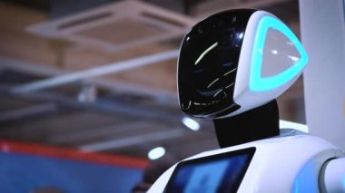 Yeni modern beyaz robot portresi. Robot onun kafa döner, kameraya doğru görünüyor. Robotlar ve yüksek robot Teknolojileri Fuarı