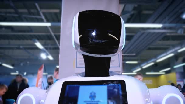 一个新的现代白色机器人的肖像。机器人转动它的头, 看着相机。机器人和高机器人技术展览会 — 图库视频影像