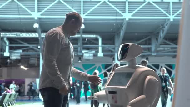 Tecnologías robóticas modernas. Un hombre se comunica con un robot, presiona un brazo mecánico de plástico al robot, apretón de manos . — Vídeo de stock