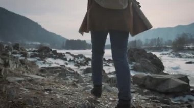 Genç bir kız ve bir donmuş nehir seyahat ellerini yukarı yükseltir. Hayat sahiptir, seyahat hoşlanıyor.