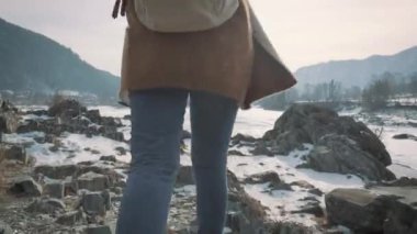 Genç bir kız ve bir donmuş nehir seyahat ellerini yukarı yükseltir. Hayat sahiptir, seyahat hoşlanıyor.