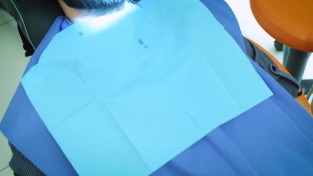 Dentista al lavoro in ufficio. Un medico donna esamina i denti e le mascelle di un paziente maschio .. — Video Stock