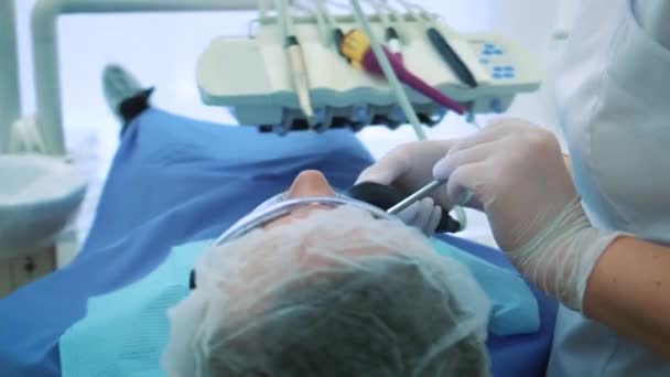 Dentista a trabalhar no escritório. Uma médica examina os dentes e mandíbulas de um paciente do sexo masculino .. — Vídeo de Stock