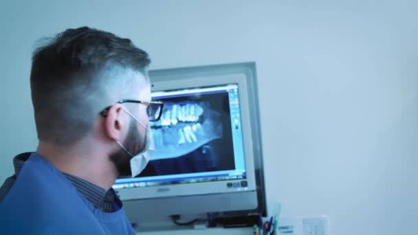 Tandläkaren studerar 3d röntgenbilden i käken — Stockvideo