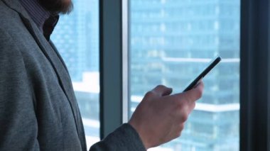 Clouse-up: telefon sms manifatura app akıllı şehir iş bölgesinde kullanarak kullanarak iş adamı. Cep telefonu açık havada elbise mutlu gülümseyerek kullanarak genç iş adamı.