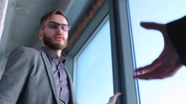 Fashionable modern young man with beard businessman shaking hands with partner. Have concluded a deal or contract. Located in a modern office in the loft style — Stock Video