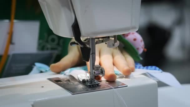 Gros plan : la fille coud sur la machine à coudre. Pose le tissu sous l'aiguille — Video