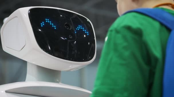 MOSCOW - RÚSSIA, 20.03.2018: um robô branco interage com um estudante em uma exposição de novas tecnologias. A criança conhece inovações — Vídeo de Stock