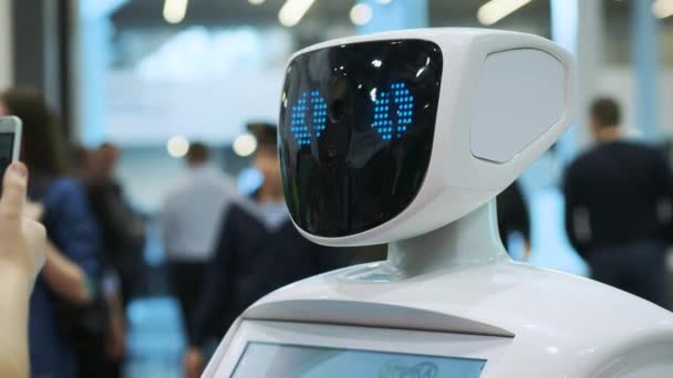 Современные роботизированные технологии. Робот смотрит в камеру на человека. Робот показывает эмоции — стоковое видео