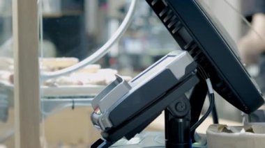 Yaşlı bir kadın bir kafede akıllı telefonuyla ödeme yapıyor. NFC 'den ödeme terminaline bir akıllı telefon bağlıyor. Akıllı telefonunla temassız ödeme. Eski nesil ve modern teknoloji