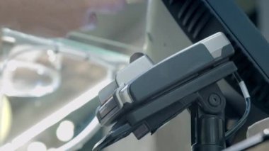 Yaşlı bir kadın bir kafede akıllı telefonuyla ödeme yapıyor. NFC 'den ödeme terminaline bir akıllı telefon bağlıyor. Akıllı telefonunla temassız ödeme. Eski nesil ve modern teknoloji