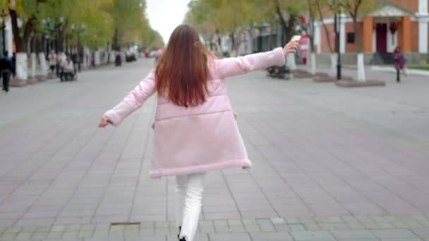 Hermosa joven bailando libremente en la ciudad. Siente una sensación de alegría, no de timidez. Rompe estereotipos, no tiene complejos psicológicos — Vídeos de Stock