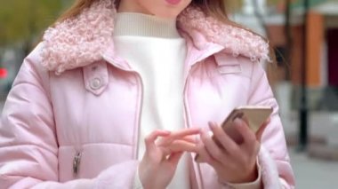 Genç ve güzel bir kız akıllı telefondan arama yapar, kablosuz beyaz kulaklık kullanır. Arkadaşlarına veya akrabalarına seslenir