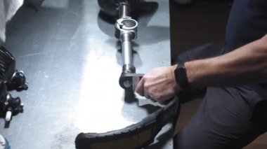Protez bacak üretimi. Bir adam bacağın bir parçasını yaratır. Bir mühendis protez bacağın mekanik eklemlerini test ediyor. Yeni spor vücut parçası