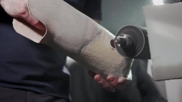 Production of a prosthetic leg. A man creates a part of the leg above the knee. Grinds the plastic part of the leg on a lathe. New body part — ストック動画