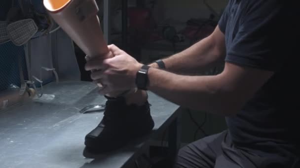 Инженер надевает кроссовки на протезную ногу. Вставляет протез в багажник, завязывает шнурки — стоковое видео