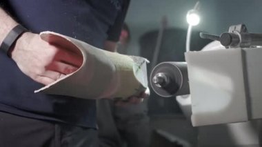 Protez bacak üretimi. Bir adam dizinin üstünde bacağın bir parçasını yaratır. Torna tezgahında bacağın plastik kısmını öğütüyor. Yeni gövde parçası