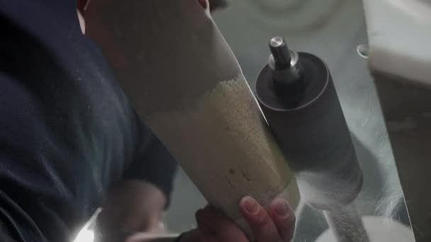 Production of a prosthetic leg. A man creates a part of the leg above the knee. Grinds the plastic part of the leg on a lathe. New body part — ストック動画