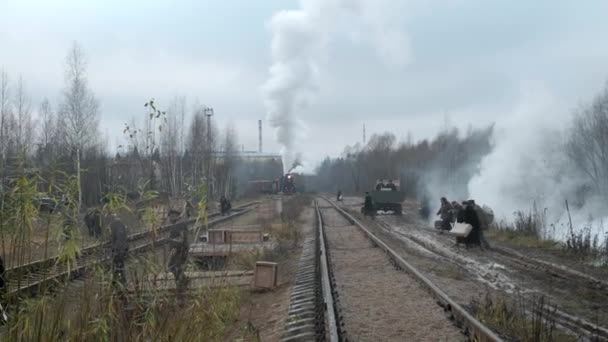 МОСКВА - 09.11.2019: Старый советский паровоз движется по рельсам во время Второй мировой войны. Эвакуирует местное гражданское население. Солдаты красной армии на страже гражданского населения — стоковое видео