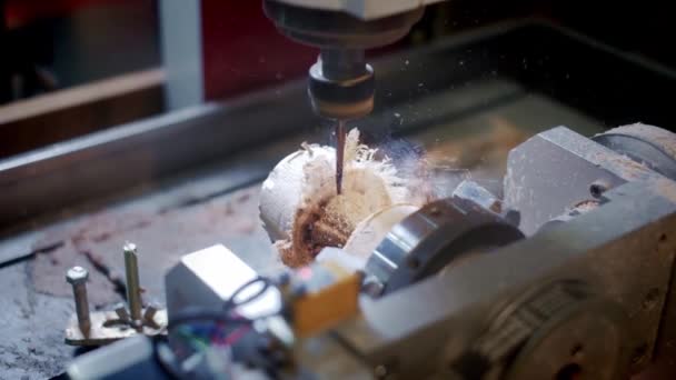 Une perceuse traite une pièce en bois. Machine à bois. Industrie du bois. Des copeaux et de la sciure de bois. Plan d'ensemble .