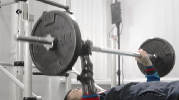 Un athlète sans main lève la barre tout en étant couché. Tient le bar avec une prothèse de main sportive professionnelle. Gym pour paralympiques — Video