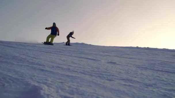 Snowboarder slides down the slope on a snowboard. Evening skiing — Stock Video