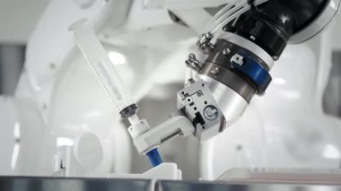 Bir robotik kolun yenilikçi kolları bir kanser hastasına kemoterapi enjekte eder. Tıpta yeni teknolojiler. İki manipülatör şırıngaya ilaç çeker. Zehirli madde enjekte edildi..