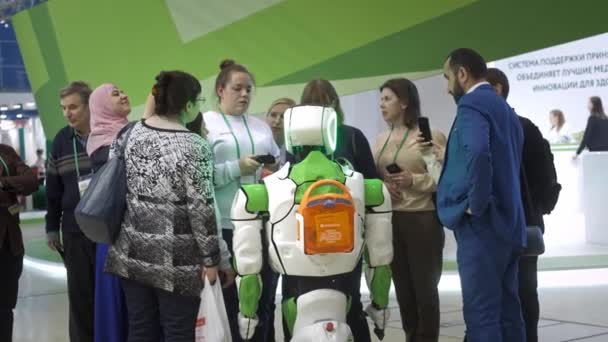 UFA RUSSIA - 17.01.2020: La gente sta intorno a un robot bianco. Parlano e toccano il robot. I visitatori della mostra comunicano con il robot . — Video Stock