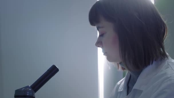 Young Girl Scientist Examines Test Tube With Blood. She studies the samples. A young scientist conducts scientific research. She is researching a virus, looking for a cure for an epidemic vaccine — 비디오