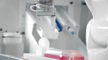 Robotik kol kemoterapi ilacı enjekte ediyor. İki manipülatör ilacı şırıngaya doldurur. Tıpta yeni teknolojiler, yenilikler. Kanser hastalarının ve enfeksiyonluların uzaktan tedavisi.