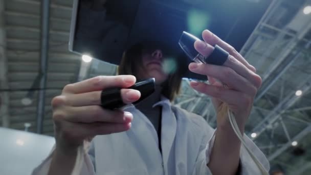 Девушка-хирург проводит операцию на пациенте в виртуальной реальности. Управляет оружием роботизированных рук. Новые технологии в медицине, инновации. Удаленное лечение онкологических больных и инфицированных — стоковое видео