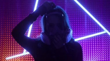 Genç kız, kulübün neon ışıklarında modellik yapıyor. Dubstep ya da punk tarzı. Kirli havadan dolayı gaz maskesi takıyor. Halka açık bir yerde Çin koronavirüsünden korunuyor..