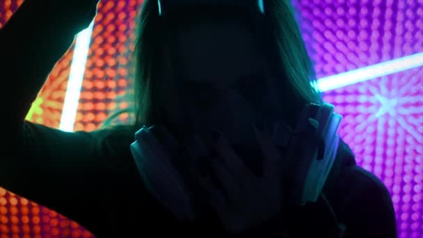 Junges Mädchen im Neonlicht des Clubs. Konzept des Dubstep oder Punkstils. Das Tragen einer Gasmaske aus schmutziger Luft. An einem öffentlichen Ort vor dem chinesischen Coronavirus geschützt. — Stockvideo