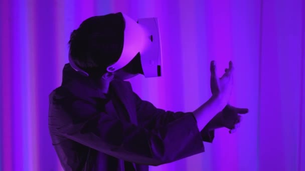 Jeune homme un joueur professionnel dans les lunettes de réalité virtuelle. Immergé dans une réalité parallèle, crée des objets architecturaux. Lunettes VR blanches futuristes. Le designer crée un nouvel art . — Video