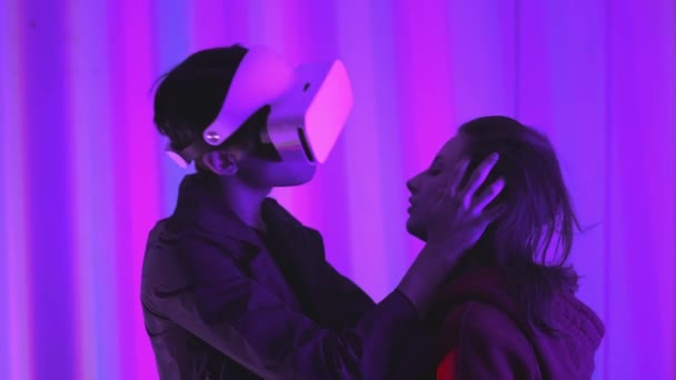 Young guy and girl a professional gamer in virtual reality glasses. Immersed in a parallel reality, creates architectural objects. Futuristic white VR glasses. The designer creates new art. — Stock Video