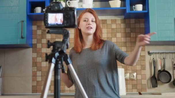 食物博客女性影响者正在厨房里录制视频或播客。制作关于健康和不健康食物的生活博客。一个女人和订户交流，要求喜欢这个视频. — 图库视频影像