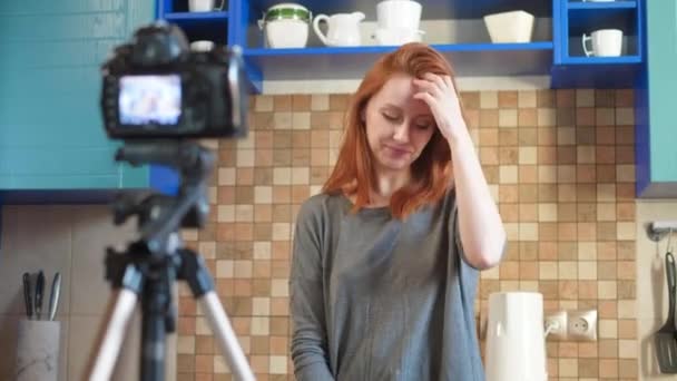 Food blogger girl influencer neemt een video of podcast op in de keuken. Maakt lifestyle blog vlog, Toont ok teken van de hand. Een vrouw communiceert met abonnees, vraagt om de video leuk te vinden. — Stockvideo