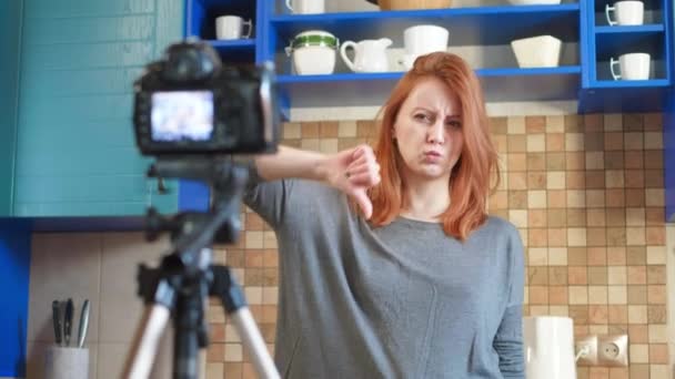 Élelmiszer blogger lány befolyásoló rögzít egy videót vagy podcast a konyhában. Lehetővé teszi az életmód blog vlog egészséges és egészségtelen ételeket. Egy nő kommunikál az előfizetőkkel, megmutatja, hogy nem szereti a kezét. — Stock videók