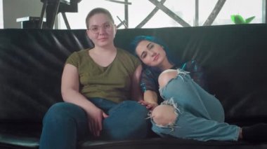 Kameraya bakan lezbiyen çiftin portresi. İki mutlu kız arkadaş. Siyah saçlı bir kız ve kel bir kadın el ele tutuşuyor. Bedava eşcinsel aşkı. Homoseksüel ilişki. Lgbt Topluluk Gururu.