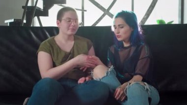 Kameraya bakan lezbiyen çiftin portresi. İki mutlu kız arkadaş. Siyah saçlı bir kız ve kel bir kadın el ele tutuşuyor. Bedava eşcinsel aşkı. Homoseksüel ilişki. Lgbt Topluluk Gururu.