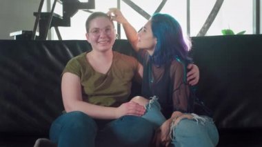 Kameraya bakan lezbiyen çiftin portresi. İki mutlu kız arkadaş. Siyah saçlı bir kız ve kel bir kadın el ele tutuşuyor. Bedava eşcinsel aşkı. Homoseksüel ilişki. Lgbt Topluluk Gururu.